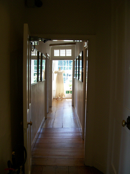 A photo of the main upstairs hallway that has a mannequin wearing a dress at the end of it