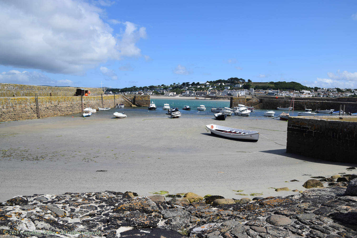 A photo of the harbour at St Michael's Mount with various boats, looking towards the mainland