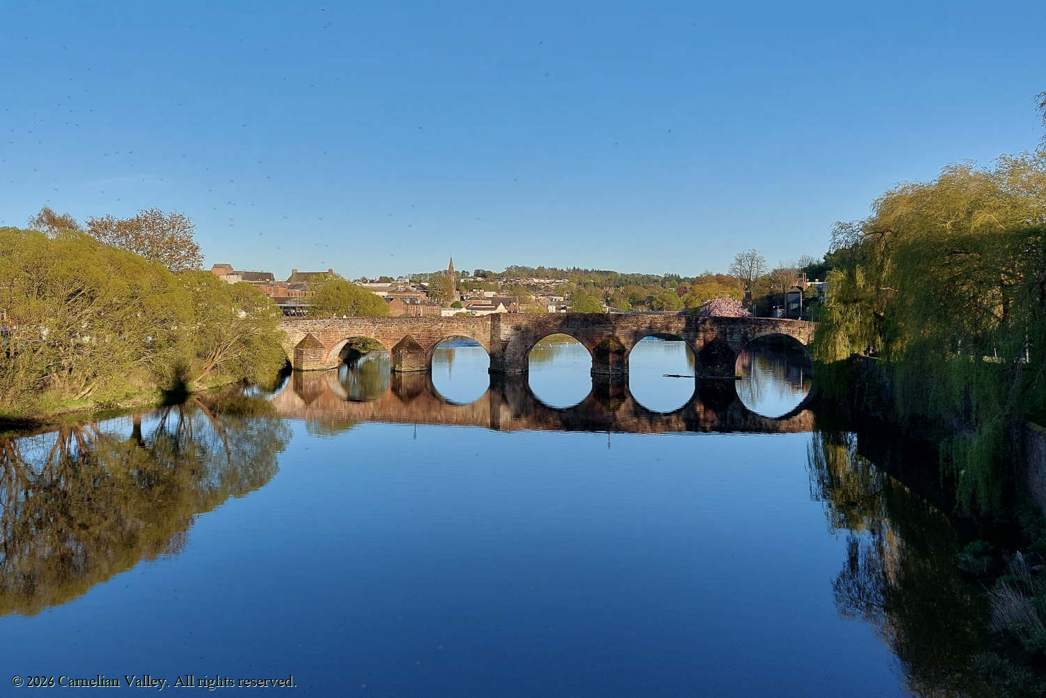 A photo of Devorgilla Bridge on the river Nith on a cloudless day in Dumfries